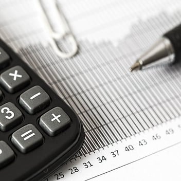 Ilustración de una calculadora y planilla de ingresos para calcular pago de impuestos