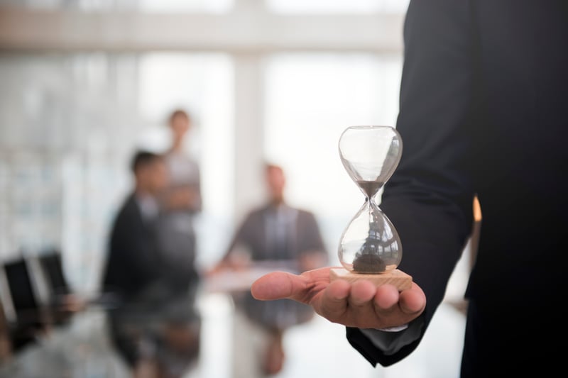 empresario-sosteniendo-un-reloj-de-arena-significa-la-importancia-de-estar-tiempo