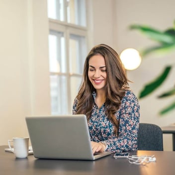 Mujer con computadora sigue pasos para abrir negocio en línea