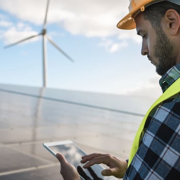 Consultor usando tablet para asesorar planta eólica