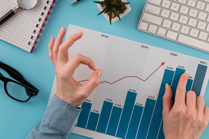 vista-superior-de-elementos-comerciales-con-tabla-de-crecimiento-y-manos-dando-un-signo-bien