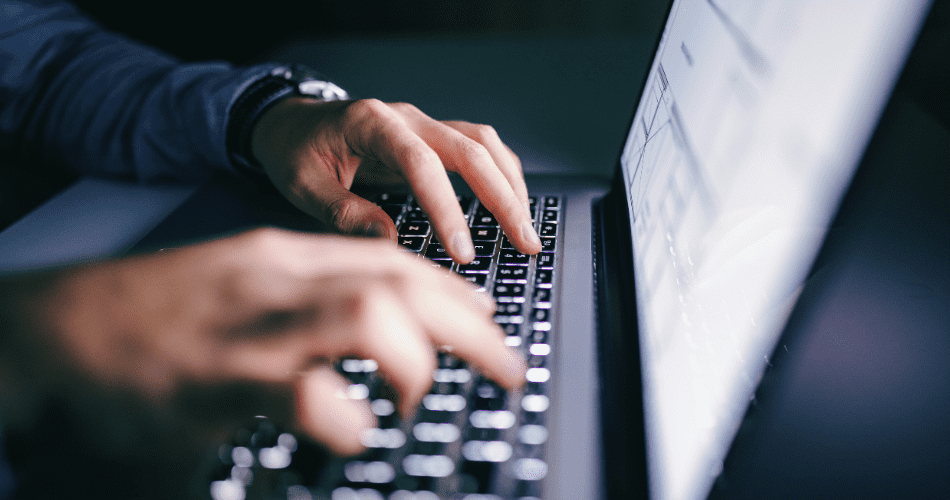 Manos masculinas escribiendo en teclado de computadora